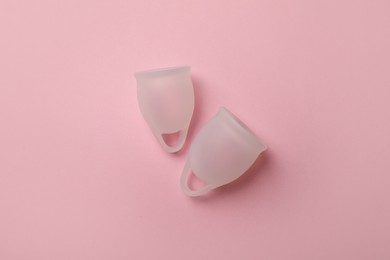 White menstrual cups on pink background, flat lay