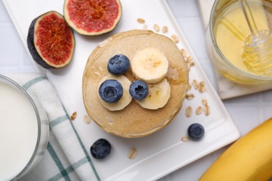 Photo of Tasty oatmeal pancakes served on white table, flat lay