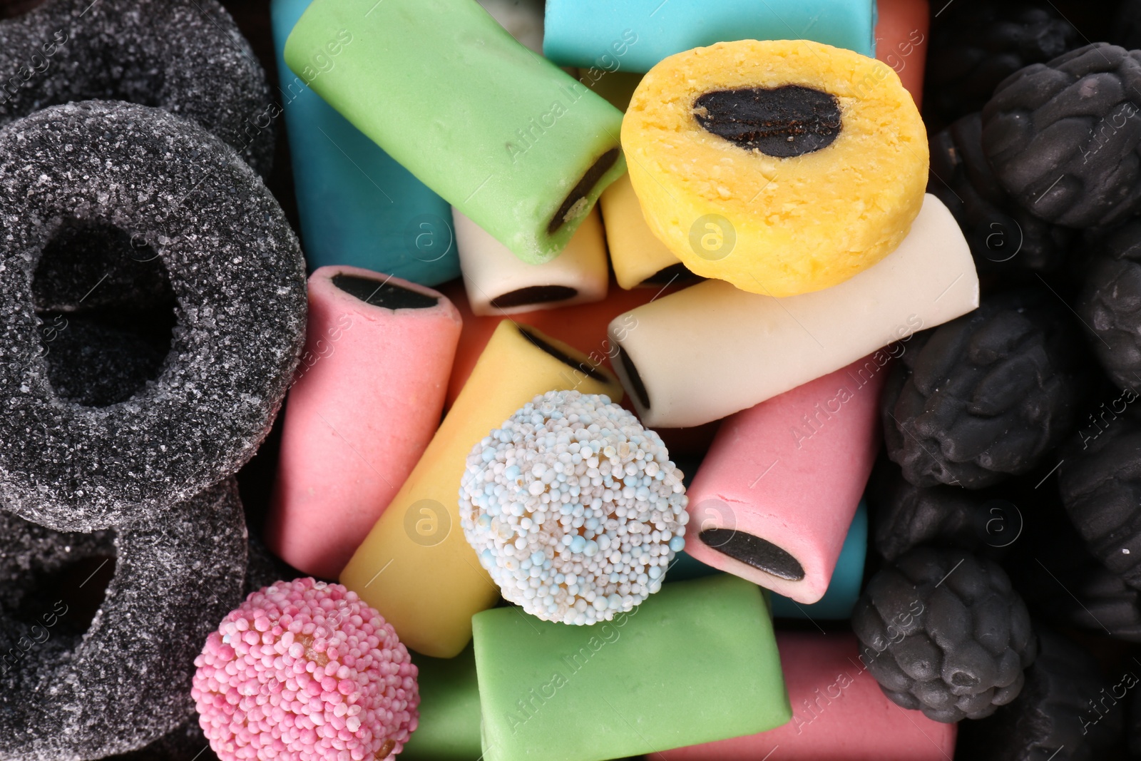 Photo of Many tasty liquorice candies as background, top view