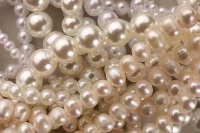 Photo of Elegant pearl necklaces as background, top view