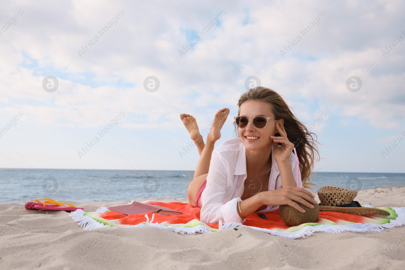 Photo of Beautiful woman lying on beach towel near sea