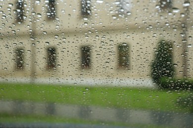 Blurred view of city street through wet car window. Rainy weather