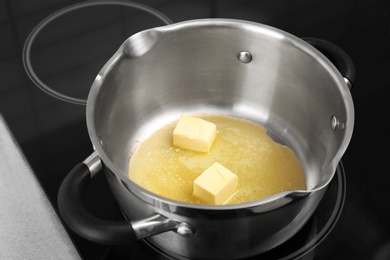 Saucepan with melting butter on electric stove, closeup