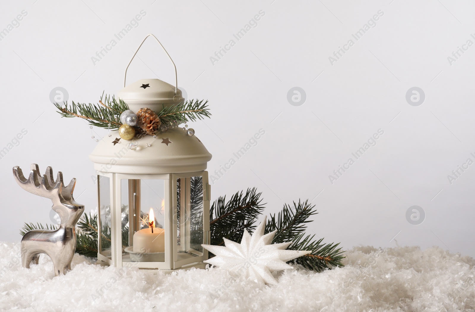 Photo of Beautiful composition with vintage Christmas lantern and festive decorations on snow against white background. Space for text