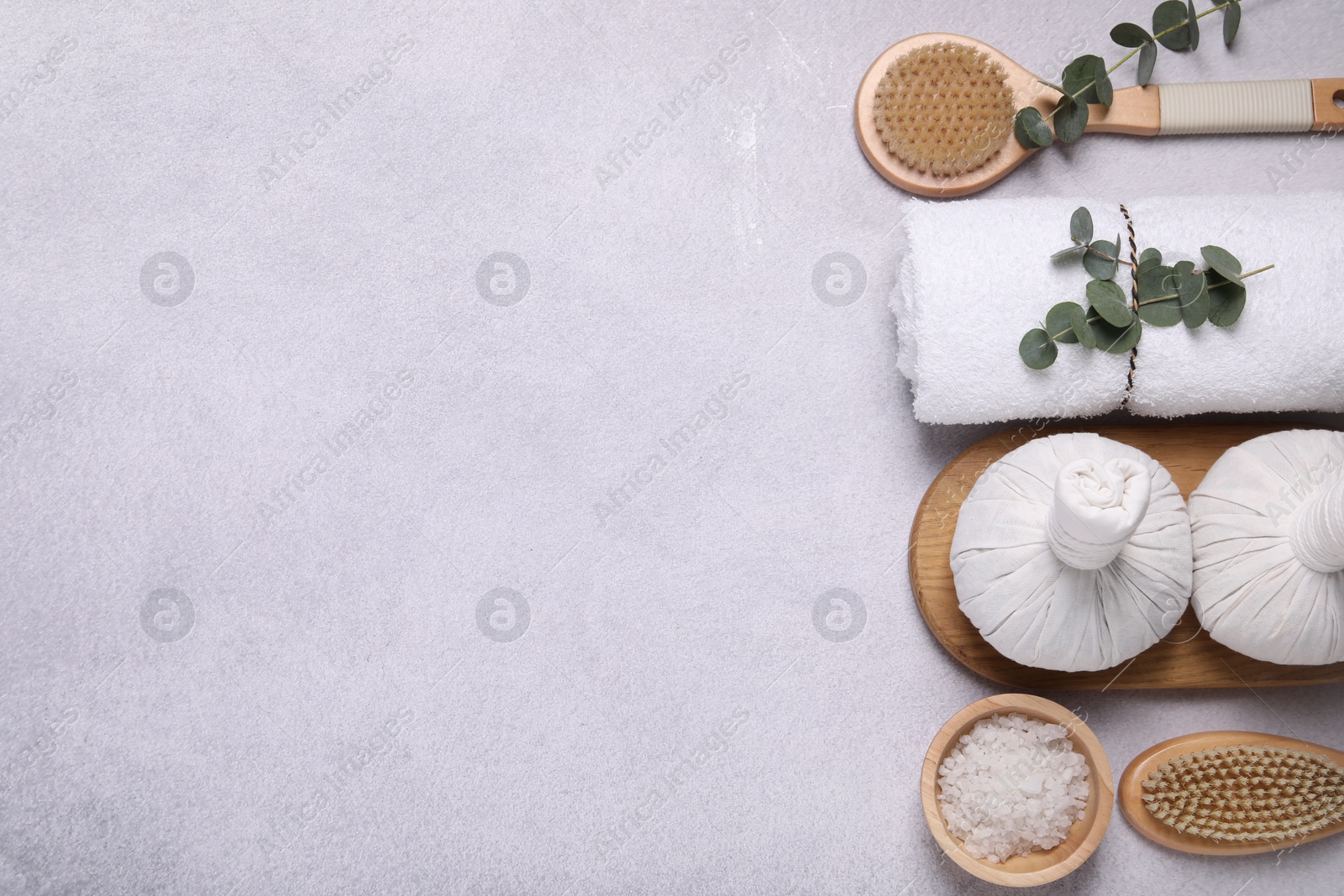 Photo of Flat lay composition with spa products and eucalyptus branches on grey table. Space for text