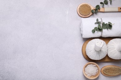 Flat lay composition with spa products and eucalyptus branches on grey table. Space for text