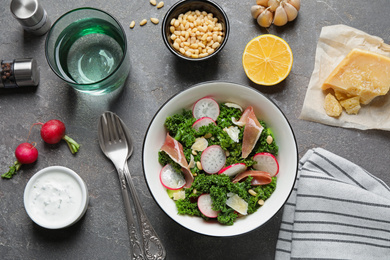 Photo of Tasty fresh kale salad on grey table, flat lay