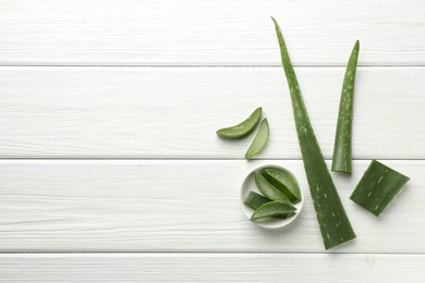 Photo of Fresh aloe vera pieces on white wooden table, flat lay. Space for text