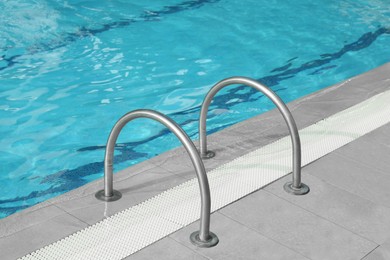 Photo of Ladder with handrails in outdoor swimming pool