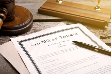 Image of Last Will and Testament, pen and gavel on wooden table, closeup