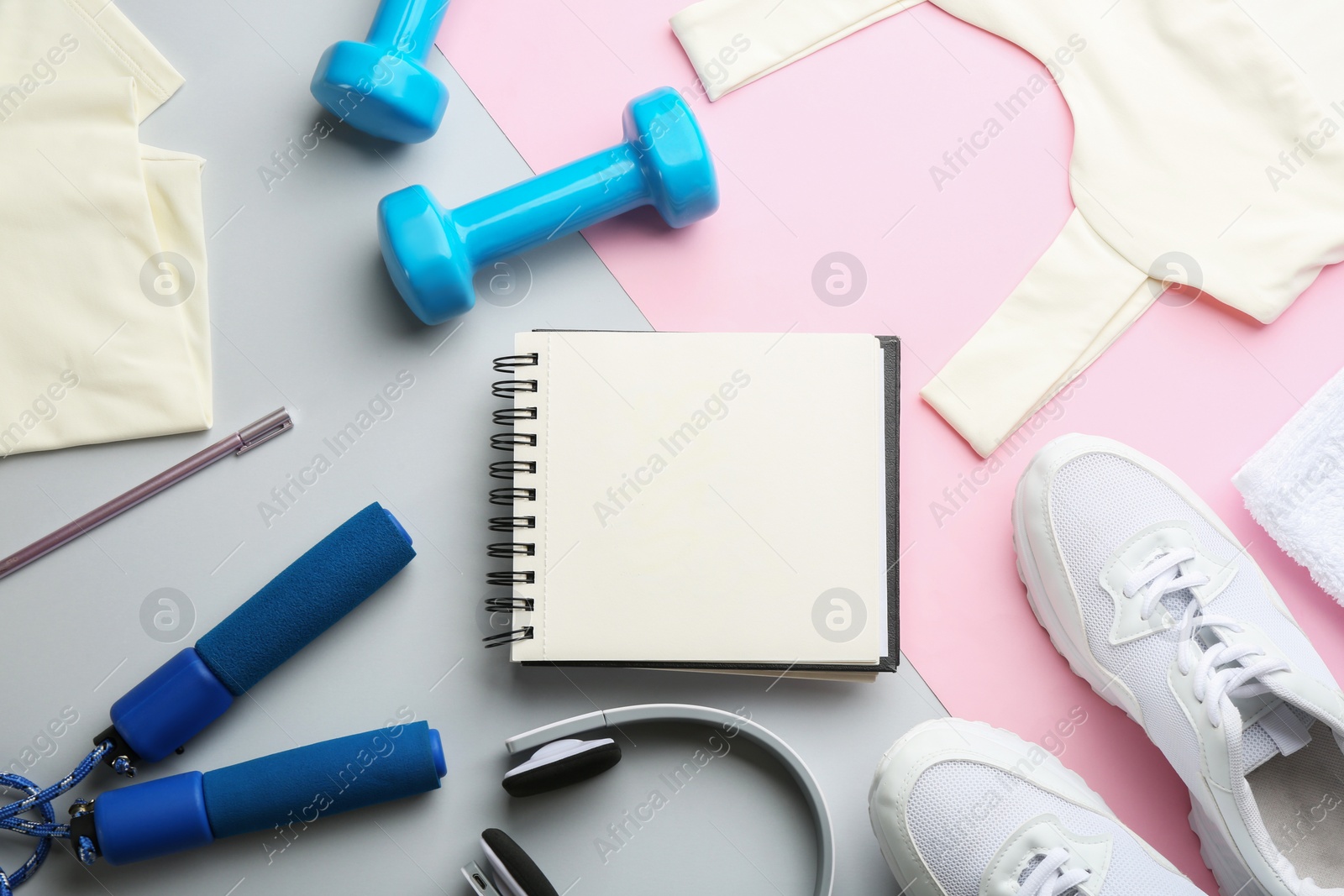 Photo of Flat lay composition with sportswear, notebook and equipment on color background. Gym workout plan