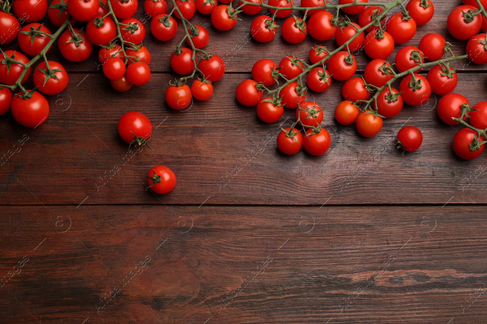 Photo of Fresh ripe cherry tomatoes on wooden table, flat lay. Space for text