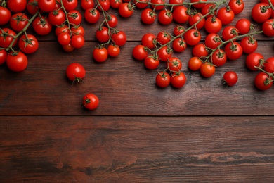 Photo of Fresh ripe cherry tomatoes on wooden table, flat lay. Space for text