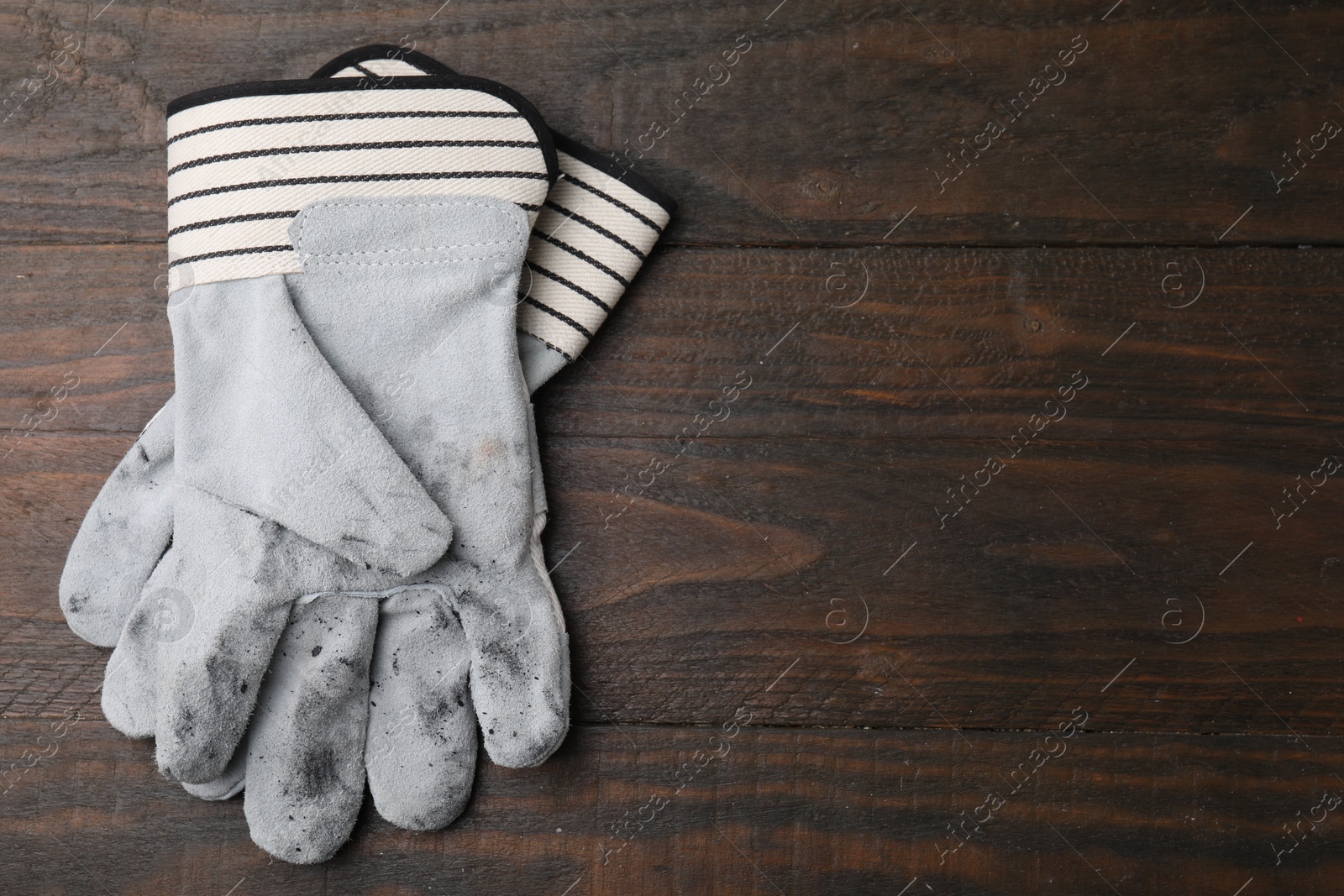 Photo of Pair of color gardening gloves on wooden table, top view. Space for text