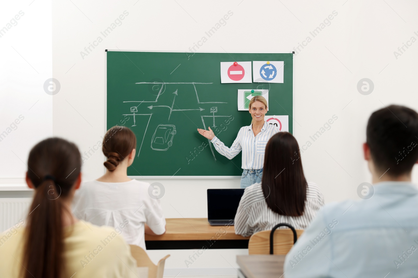 Photo of Teacher explaining traffic rules to audience during lesson in driving school