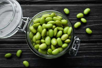 Jar of edamame beans on black wooden table, flat lay