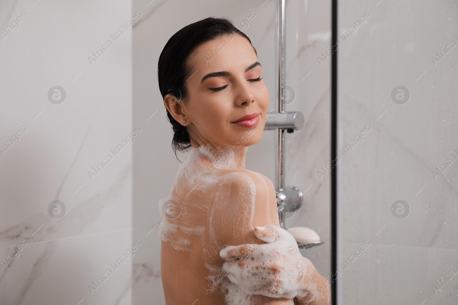 Photo of Beautiful young woman taking shower at home