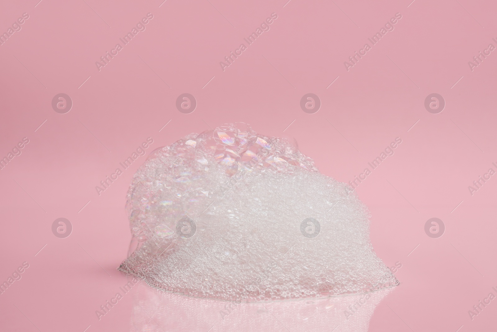 Photo of Drop of fluffy bath foam on pink background