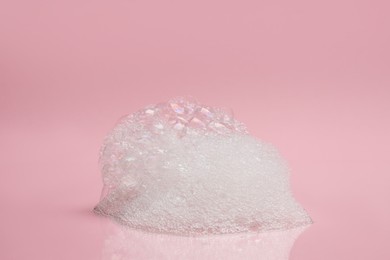Photo of Drop of fluffy bath foam on pink background