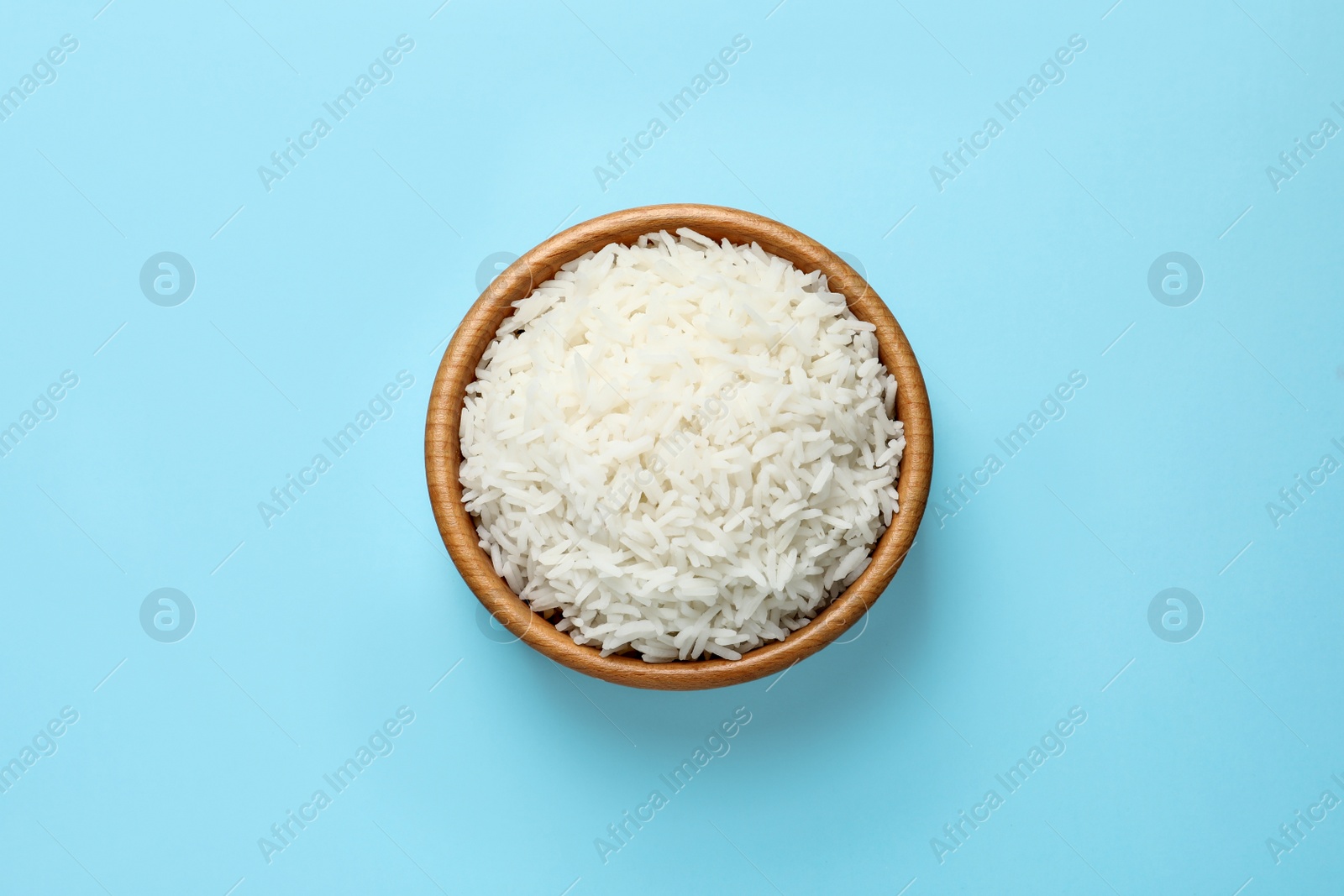 Photo of Bowl of tasty cooked rice on color background, top view