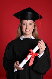 Photo of Happy student with diploma on red background