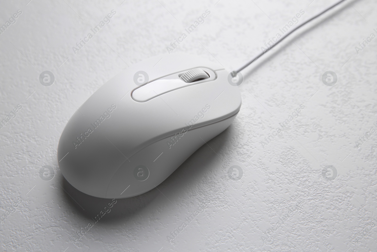 Photo of One wired mouse on light textured table, closeup