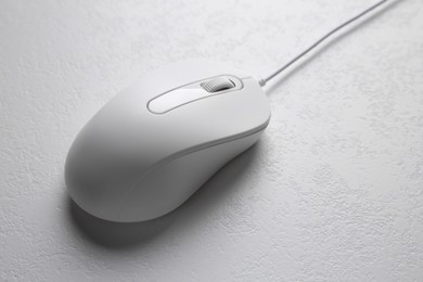 Photo of One wired mouse on light textured table, closeup