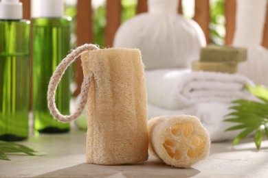 Natural loofah sponges on grey textured table