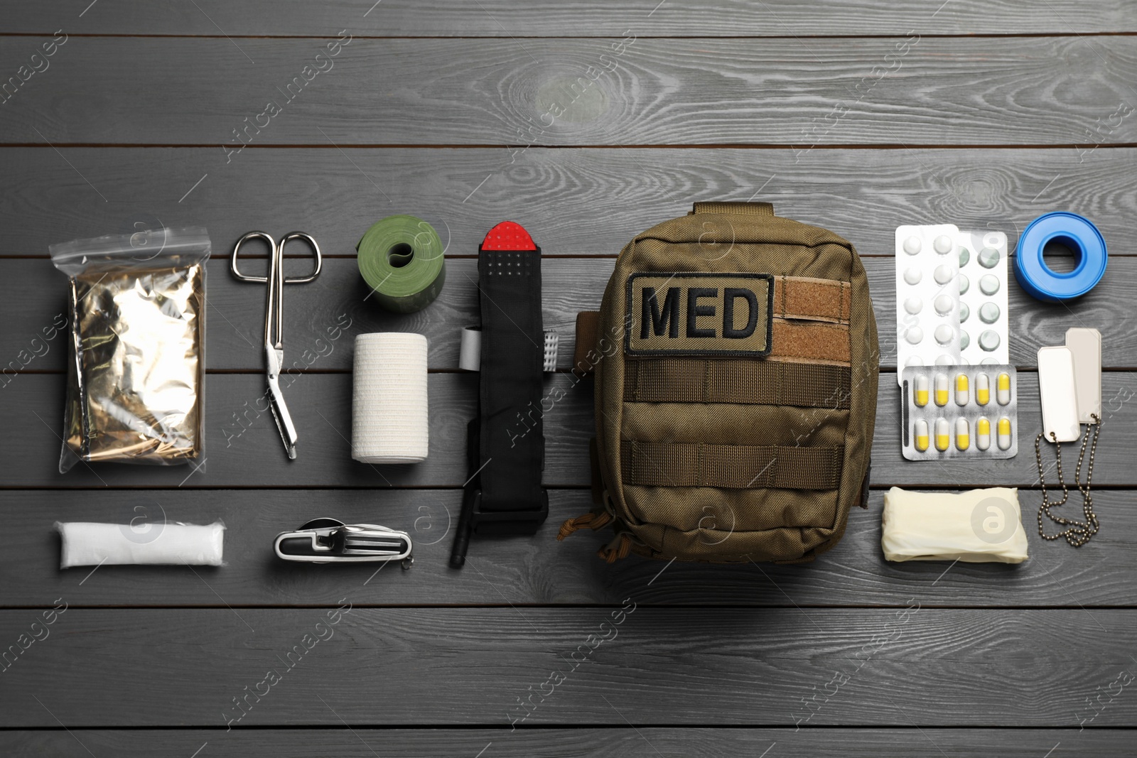 Photo of Military first aid kit on wooden table, flat lay