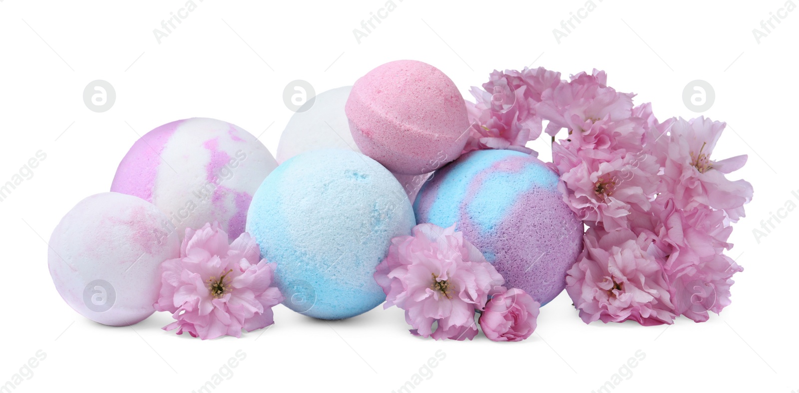 Photo of Fragrant bath bombs and sakura flowers on white background