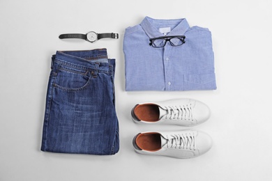 Flat lay composition with jeans, shirt and accessories on white background