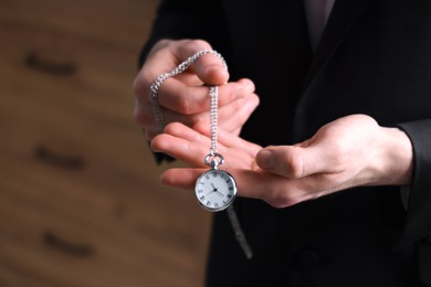 Photo of Man holding chain with elegant pocket watch, closeup. Space for text