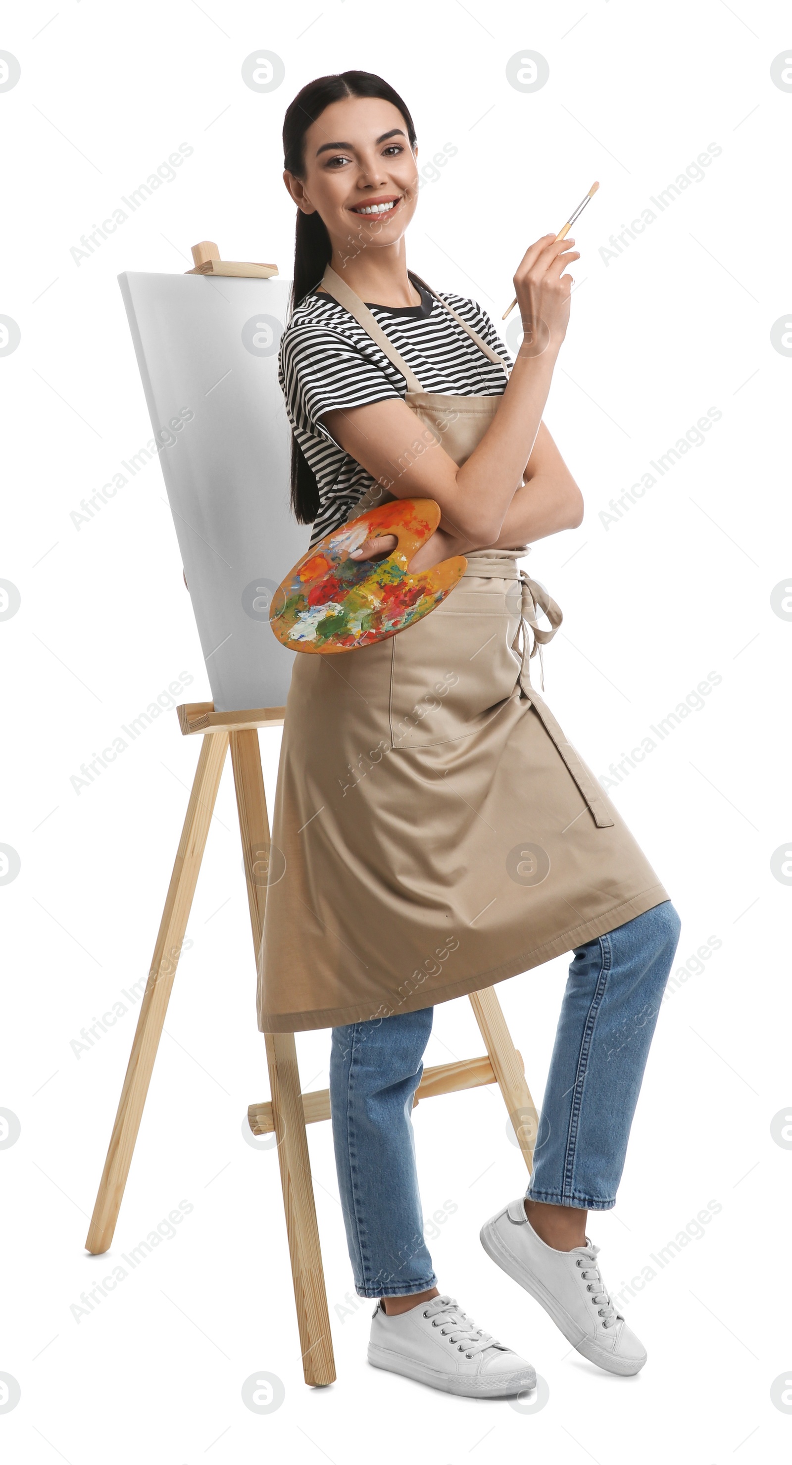 Photo of Young woman with drawing tools near easel on white background