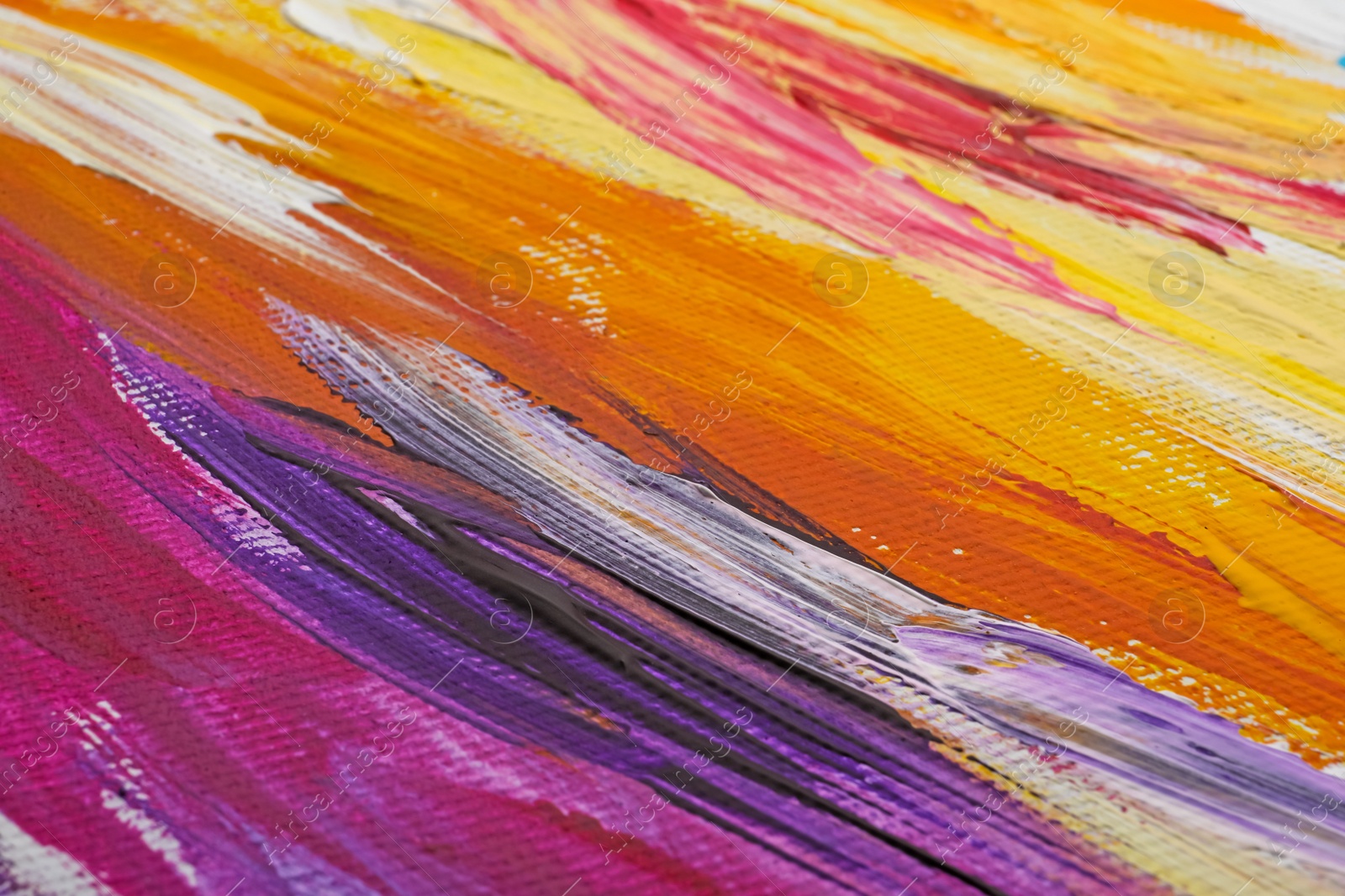 Photo of Beautiful strokes of colorful oil paints on white canvas as background, closeup