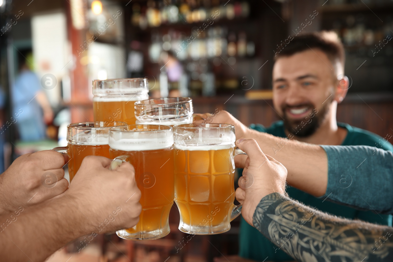 Photo of Friends clinking glasses with beer in pub