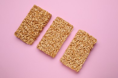 Puffed rice bars (kozinaki) on pink background, flat lay