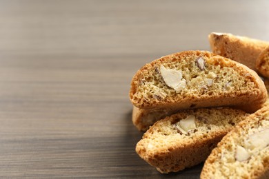 Photo of Traditional Italian almond biscuits (Cantucci) on wooden table, closeup. Space for text