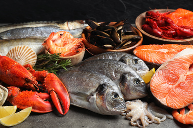 Photo of Fresh raw fish and different seafood on grey table