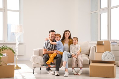 Happy family sitting on couch in new apartment. Moving day