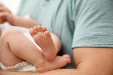 Man holding his newborn baby, closeup view