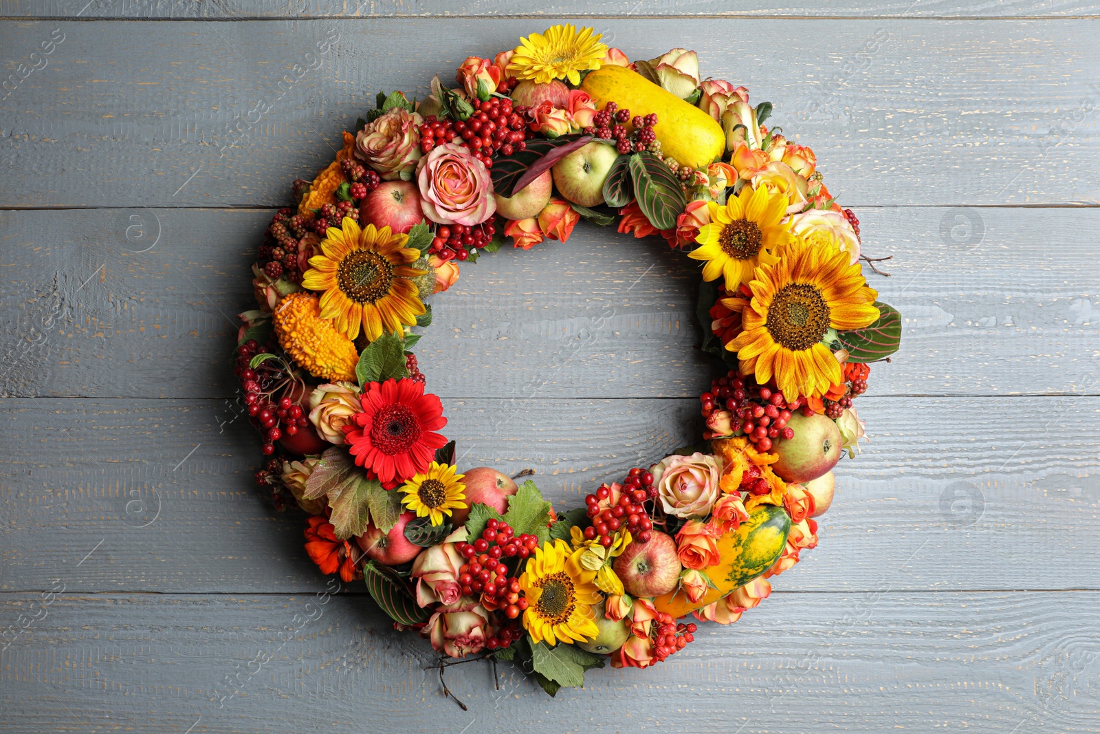 Photo of Beautiful autumnal wreath with flowers, berries and fruits on light grey wooden background, top view. Space for text