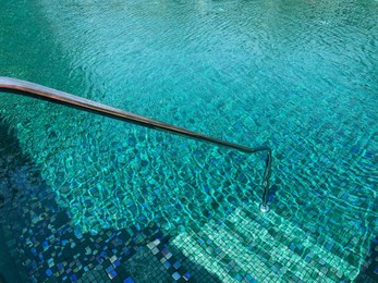 Metal rail and steps in outdoor swimming pool