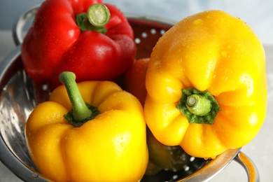 Photo of Colander with raw ripe paprika peppers, closeup