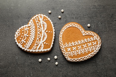 Tasty heart shaped gingerbread cookies on black table, flat lay