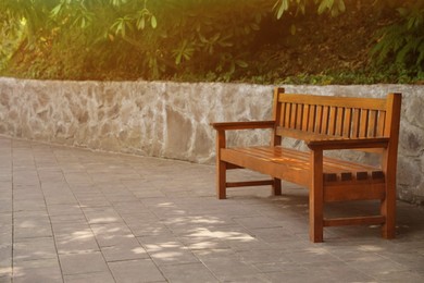 Photo of Beautiful wooden bench in park, space for text