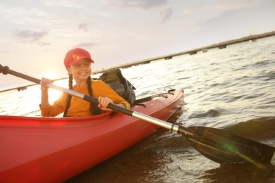 Photo of Happy girl kayaking on river. Summer camp activity