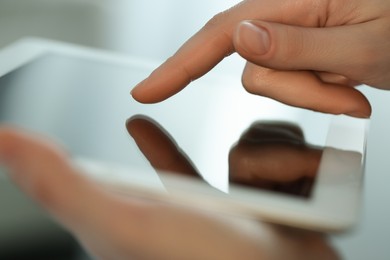 Photo of Closeup view of woman using modern tablet on blurred background