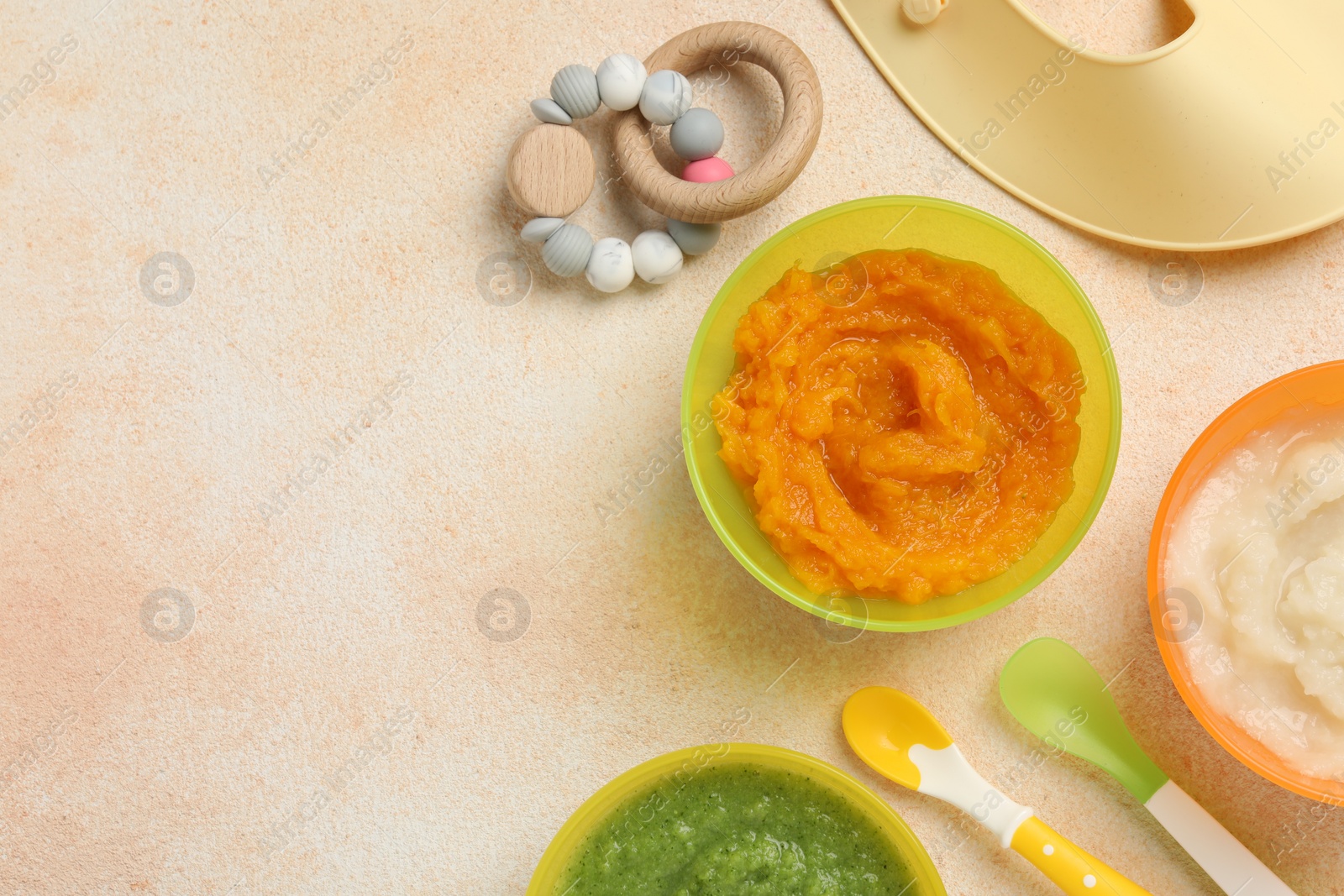 Photo of Baby food. Different tasty puree in bowls served on beige textured table, flat lay. Space for text