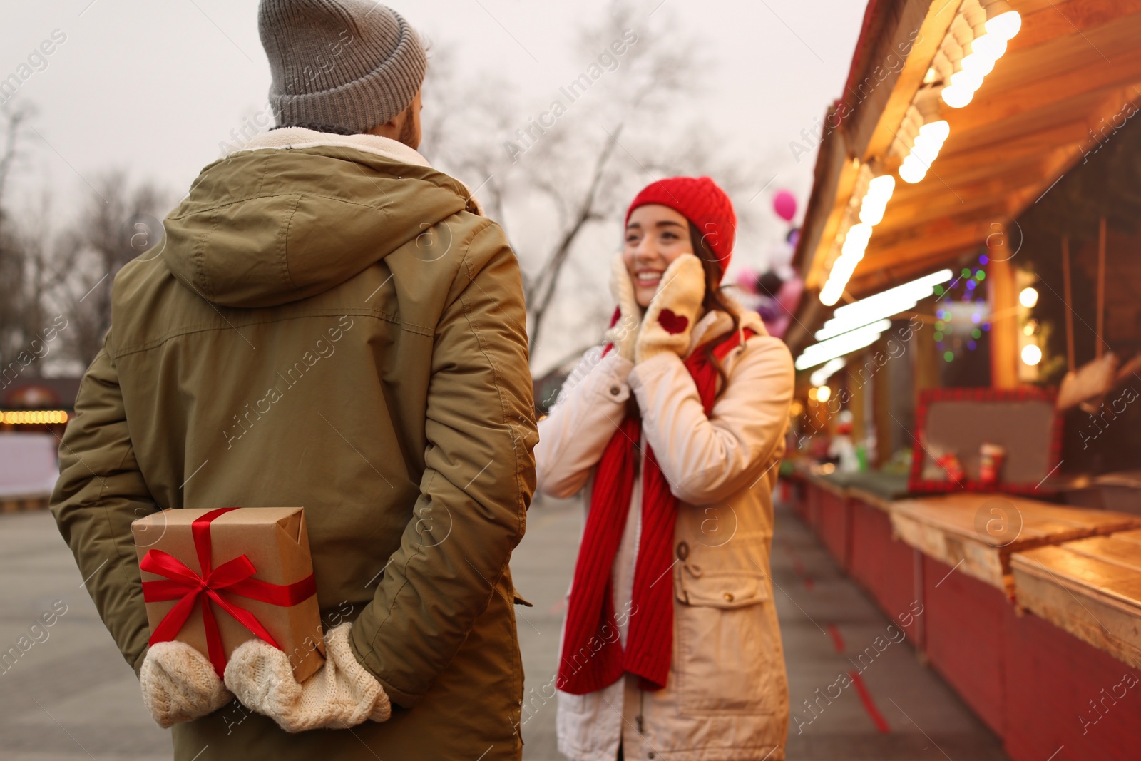 Photo of Lovely couple at winter fair, focus on Christmas present