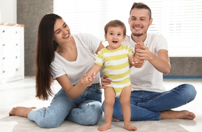 Photo of Happy family with adorable little baby at home